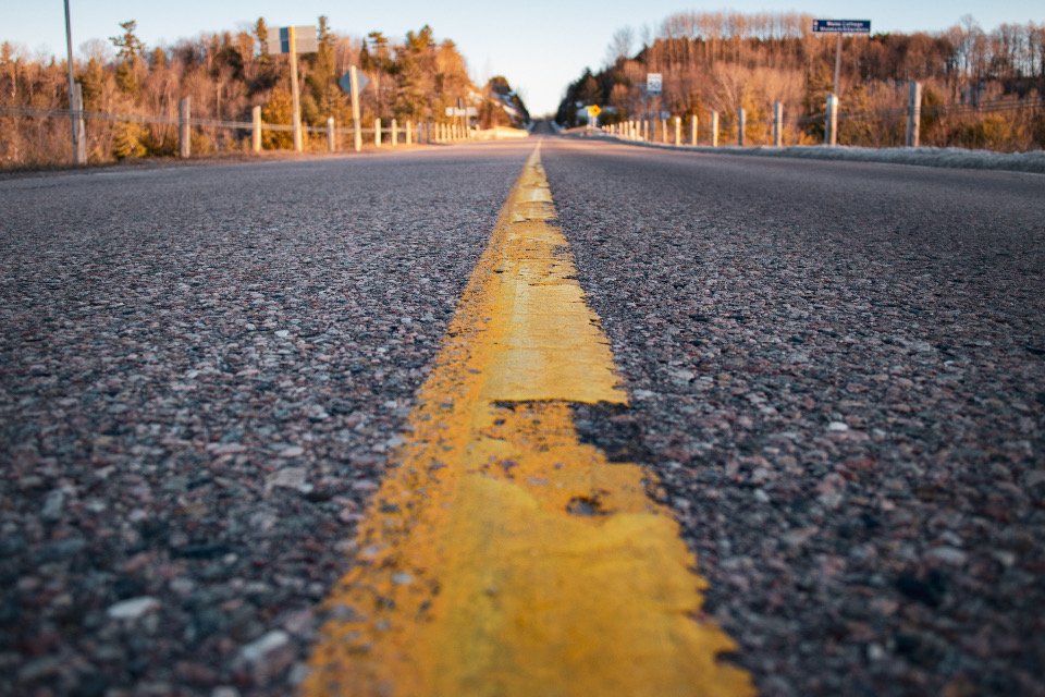 A gold center line on an open road stretching toward the horizon